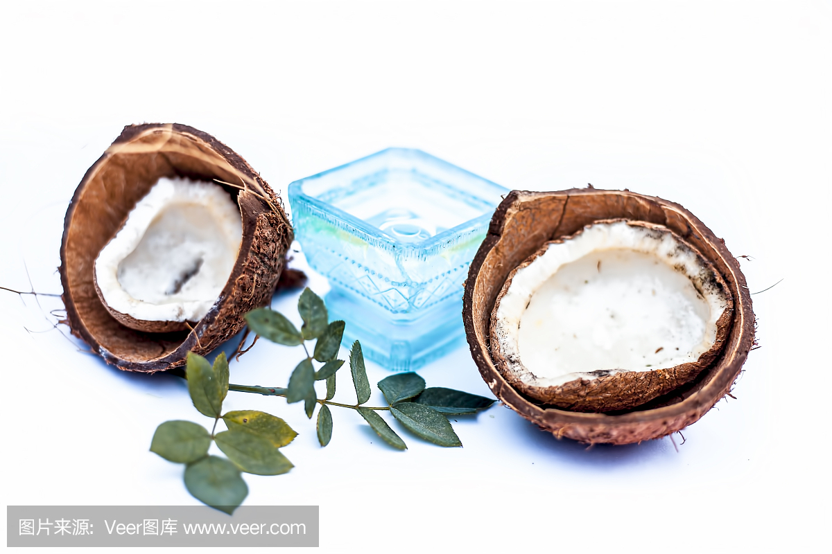 近距離的原料有機(jī)椰子油與原料椰子隔離在白色的藍(lán)色碗。